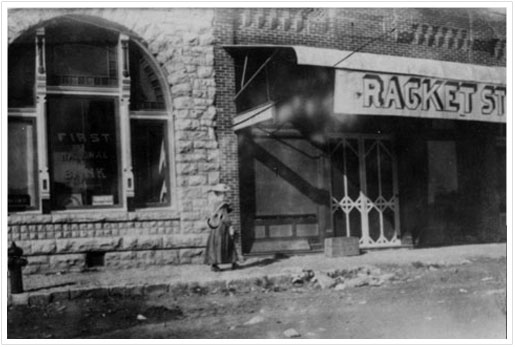 Exterior view of portion of First National Bank building and adjacent ‘Racket’ Store - early 1900s